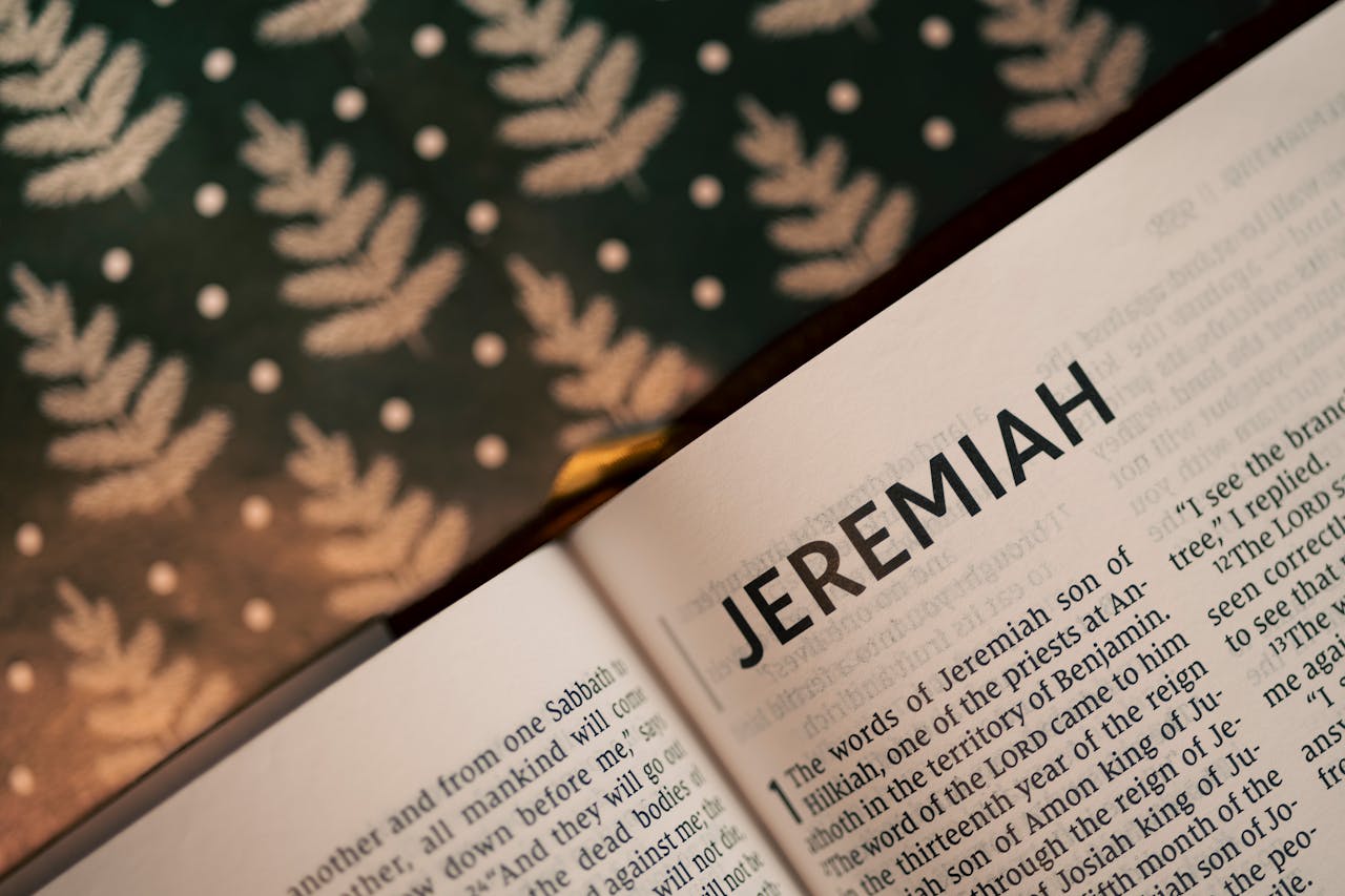 The Art of Drawing Readers In: Your attractive post title goes here Close-up of the Book of Jeremiah in an open Bible with patterned background.
